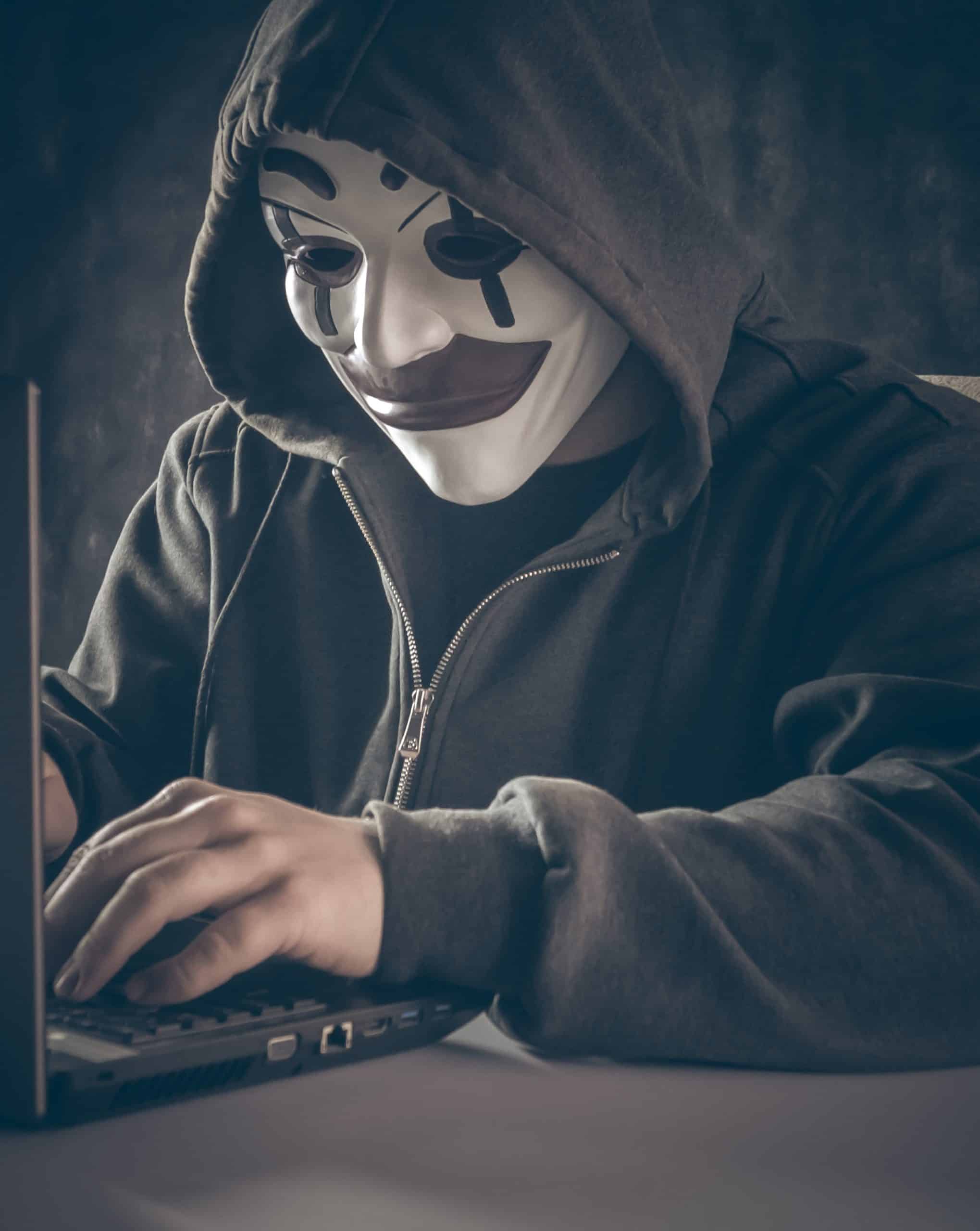 A disguised man committing fraud with a laptop, to illustrate for Occupational, Internal & Employee Fraud- What & Why, Pt. 1 of 2, by Rolf Neuweiler, a2zCFO.com
